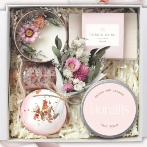 Compact orchid and jasmine spa gift box for women, including a soy candle, bath bomb, handmade soap, salt scrub, bath salts, and dried flowers, perfect for a relaxing at-home spa experience.