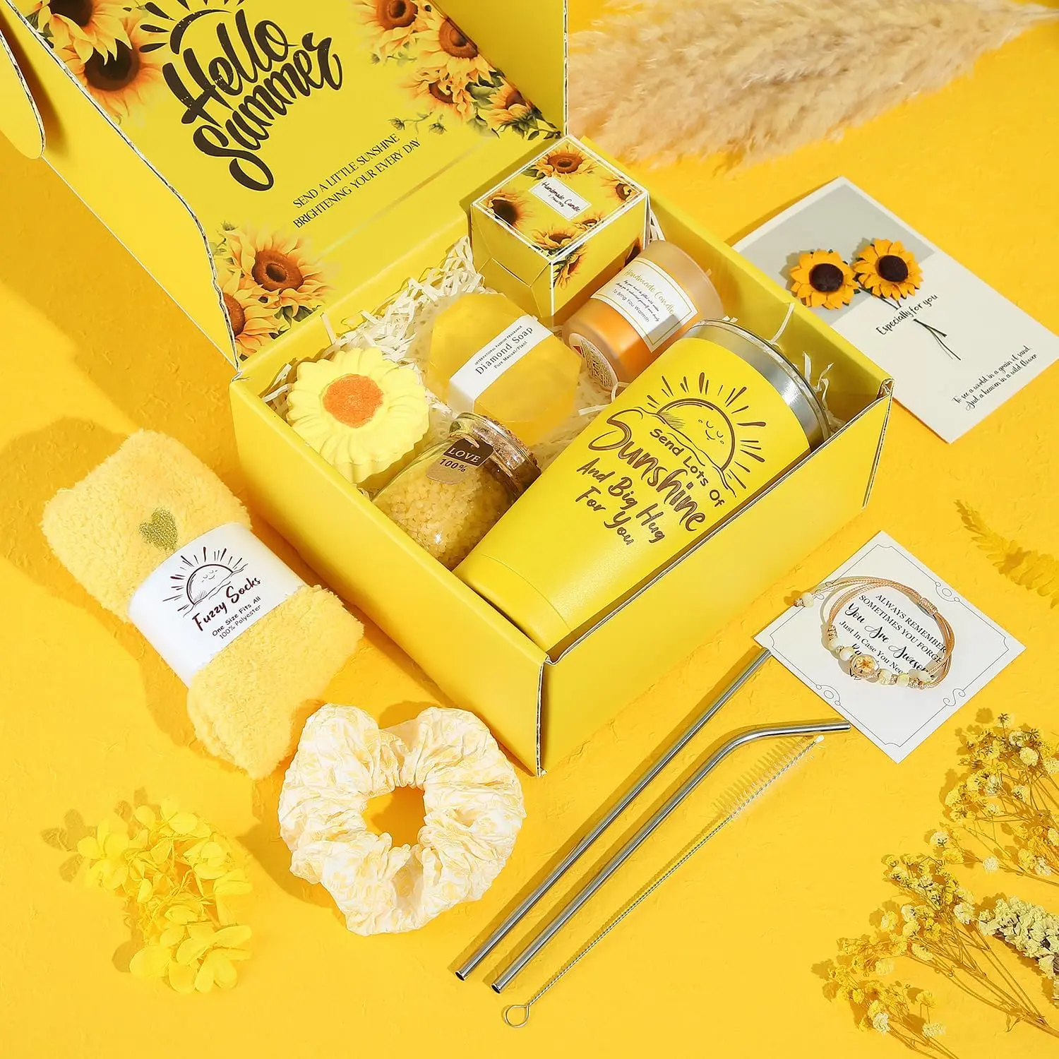 This spa gift set for women includes a sunflower-themed bath bomb, scented candle, tumbler, jewelry, and other self-care items in a beautifully packaged gift box.