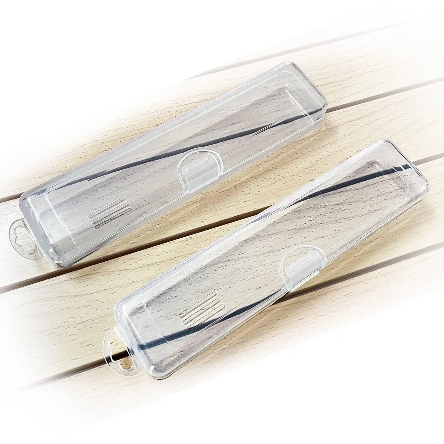 This image shows two clear plastic tongue scraper cases, perfect for travel and storage of tongue scrapers and other small items.