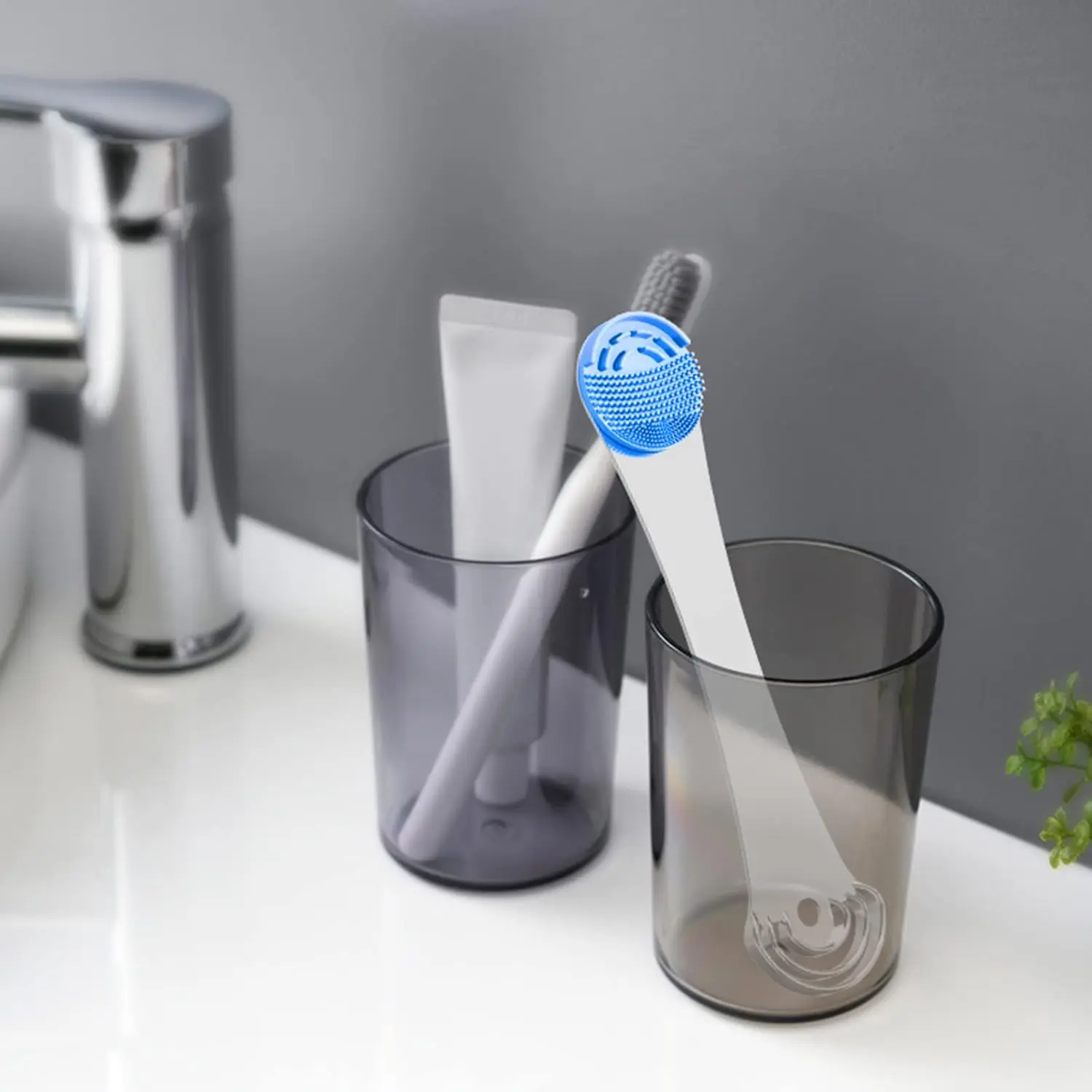 Blue tongue scraper with stainless steel handle and replacement silicone pads effectively cleans the tongue, removes debris, and improves oral hygiene for adults and kids, promoting fresh breath.