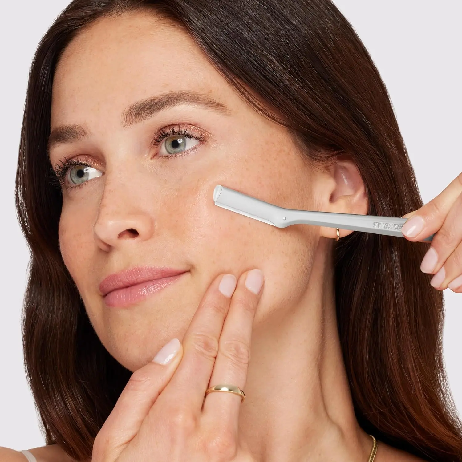 Silver Tweezerman facial razor dermaplaner for removing peach fuzz and exfoliating skin, comes with three replacement blades.