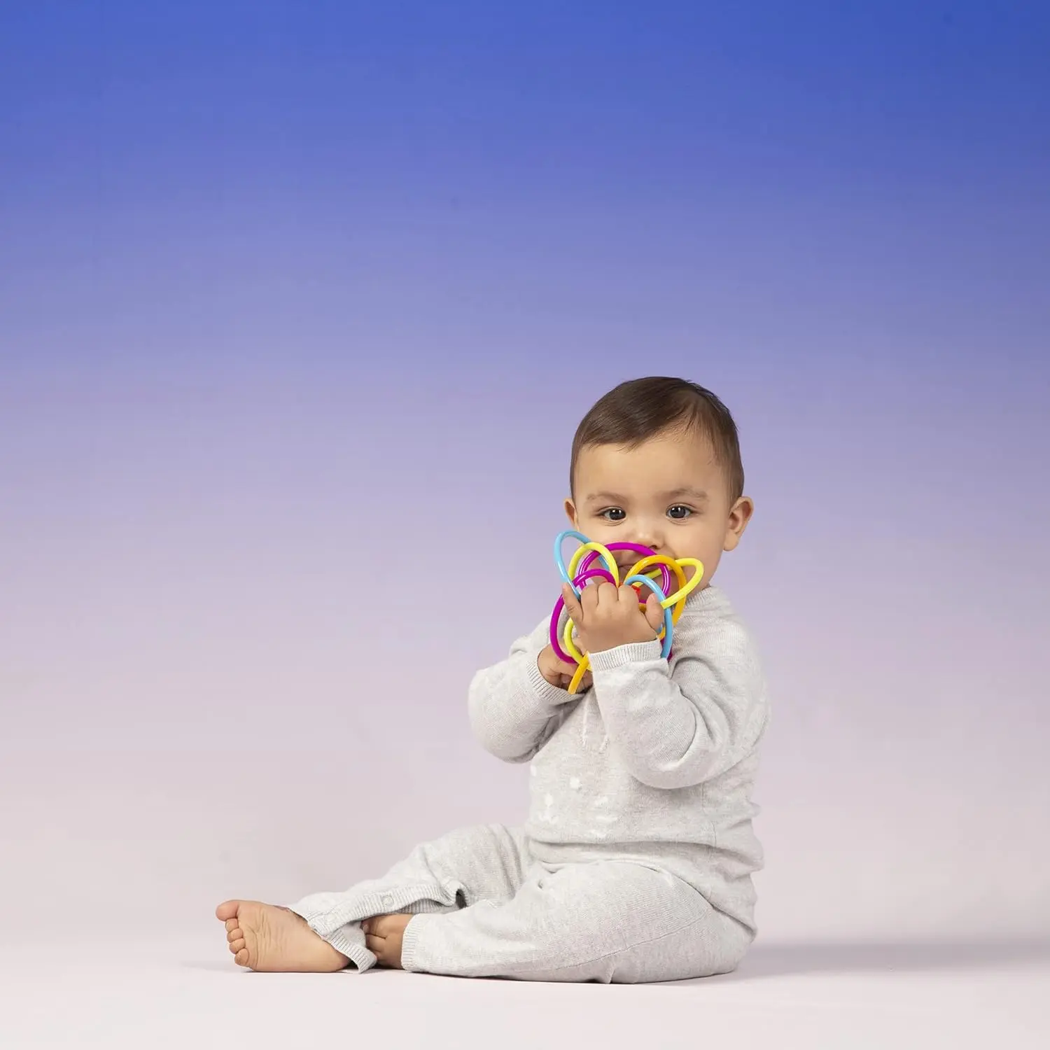 The Winkel rattle and sensory teether toy features colorful, soft tubes perfect for soothing teething babies and developing motor skills.
