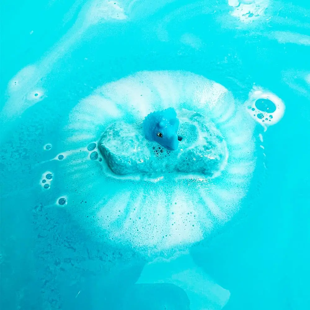 Six colorful Zimpli Kids bath bombs with surprise dinosaur toys inside, perfect as a fun and safe children's bath toy and birthday gift, made in the UK.